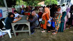 Petugas melayani warga saat penyaluran bantuan langsung tunai (BLT) Kemensos di Kecamatan Ciseeng, Bogor, Jawa Barat, Senin (28/11/2022). Setiap Keluarga Penerima Manfaat (KPM) mendapat BLT BBM sebesar Rp300ribu, Sembako Rp600 ribu dan bantuan PKH (Program Keluarga Harapan) sebesar Rp600 ribu. (merdeka.com/Arie Basuki)