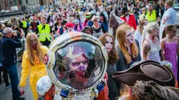 Sejumlah orang menggunakan kostum seperti zombie berjalan di tengah kota dalam parade "Zombie Walk" di Stockholm, Swedia, Sabtu (19/8). Zombie Walk adalah acara yang rutin dilakukan saat musim panas tiba, tepatnya akhir Agustus. (Jonathan NACKSTRAND/AFP)