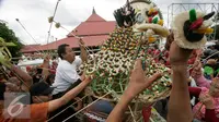 Warga berebut mengambil sesuatu di gunungan saat Grebeg Idul Adha, Yogyakarta, Selasa (13/9). Acara tahunan ini menjadi salah satu daya tarik kota Yogyakarta. (Liputan6.com/Boy Harjanto)