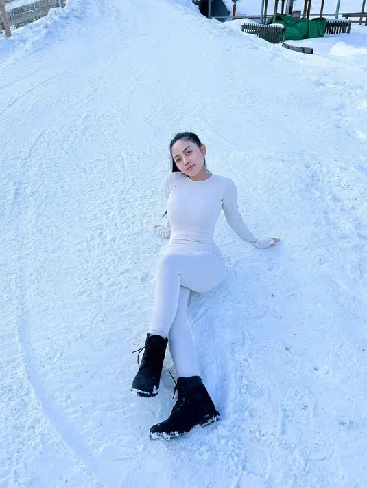 Rachel Vennya juga baru saja selesai berlibur ke Swiss. Di foto ini, Rachel terlihat berpose duduk di tengah salju mengenakan outfit serba putih. Ia mengenakan atasan lengan panjang rajut yang serasi dengan celana panjangnya, dipadu dengan midi boots hitam. [Foto: Instagram/rachelvennya]