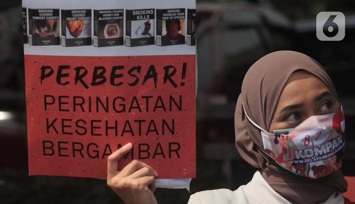 Seorang wanita dari Massa Aliansi Kompak menujukkan poster tuntutan di depan Kemenkes, Jakarta, Kamis (26/11/2020). Aksi bertujuan untuk memberikan surat somasi kedua untuk segera menyelesaikan revisi Peraturan Pemerintah No. 109 Tahun 2012 (PP 109/2012). (Liputan6.com/Herman Zakharia)