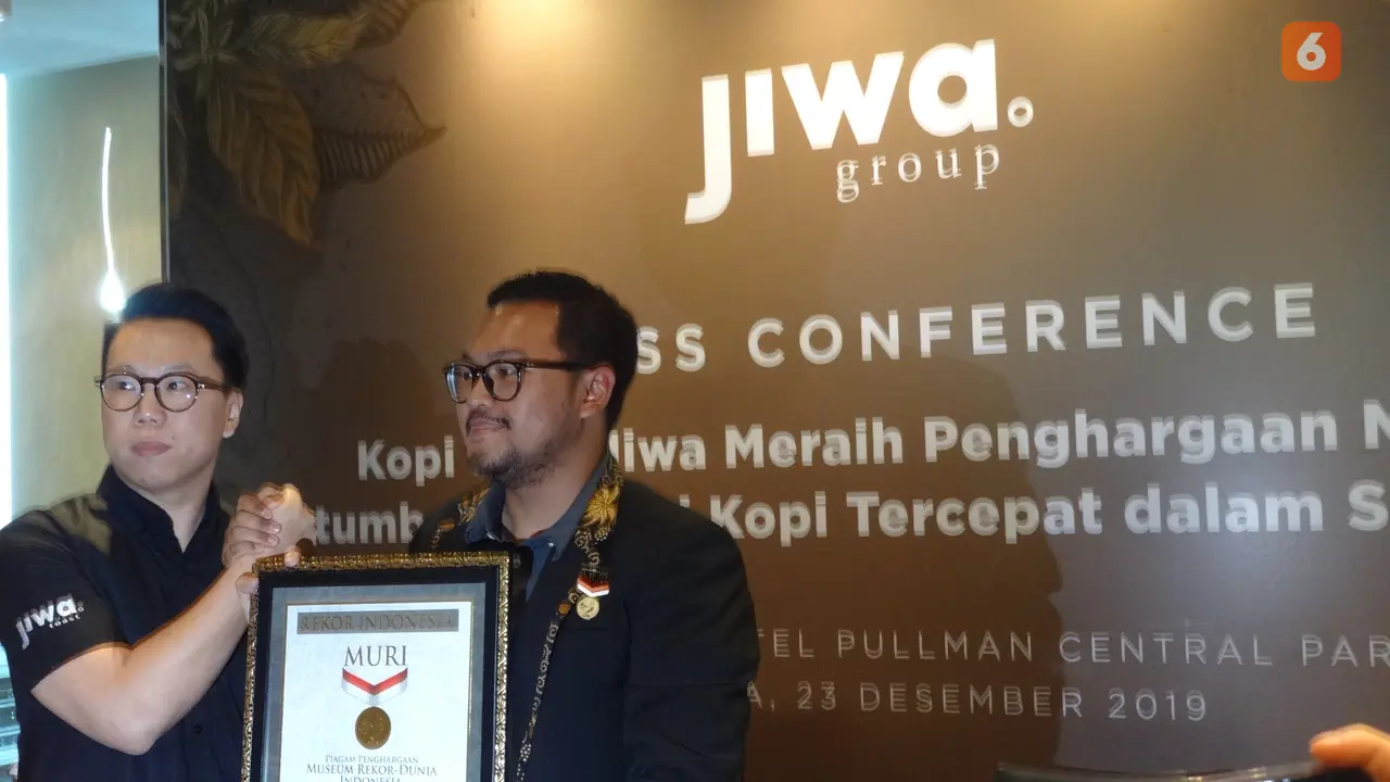 Penyerahan piagam MURI sebagai Rekor Pertumbuhan Kedai Kopi Tercepat Dalam Satu Tahun oleh Senior Manager MURI Andre Purwandono (kiri) kepada Founder Kopi Janji Jiwa Billy Kurniawan (kanan). (dok. Liputan6.com/Adhita Diansyavira)