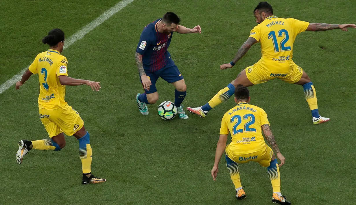 Pemain Barcelona, Lionel Messi dikepung pemain Las Palmas saat berusaha mencetak gol pada pertandingan Liga Spanyol di Camp Nou, Senin (2/10) dini hari. Dua gol Messi mewarnai kemenangan Barcelona3-0. (AP/Manu Fernandez)