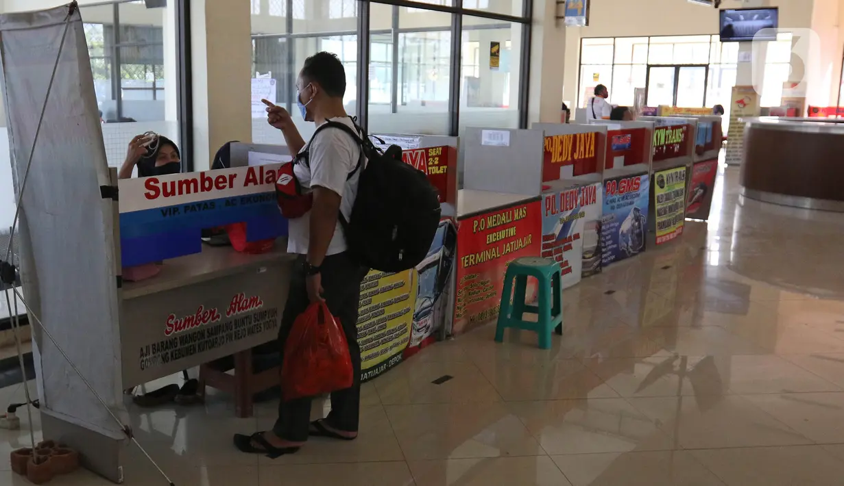 Penjaga tiket bus berbincang dengan calon penumpang di Terminal Jatijajar, Depok, Jawa Barat, Senin (6/7/2020). Terminal tipe A tersebut kembali mengoperasikan layanan bus Antar Kota Antar Provinsi (AKAP) dengan menerapkan protokol kesehatan. (Liputan6.com/Herman Zakharia)