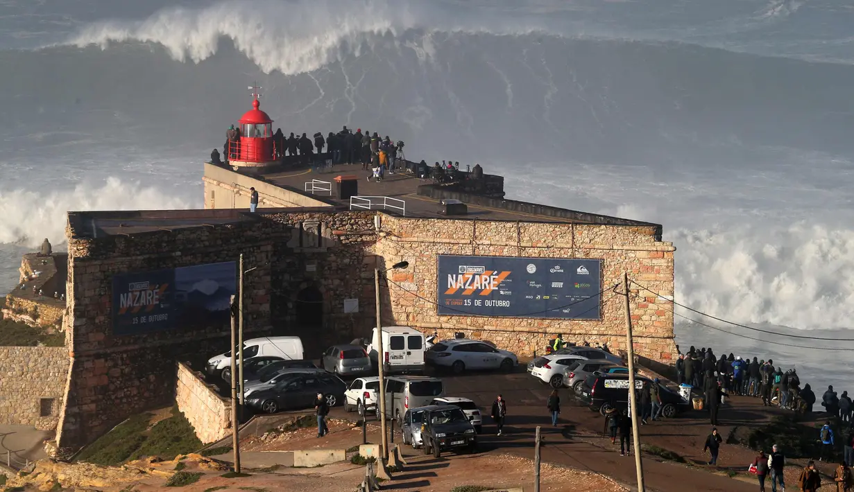 Warga berkumpul di mercu suar Nazare untuk menyaksikan sesi selancar ombak besar di Praia do Norte, atau pantai utara, di Nazare, Portugal, (18/1). (AP Photo / Armando Franca)