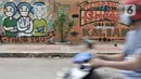Pengendara melintas di depan mural dukungan untuk tim medis Covid-19 di kawasan Sunter, Jakarta, Rabu (27/5/2020). Mural bergambarkan sosok tim medis dan ungkapan doa ini berada di seberang RS Darurat Wisma Atlet yang dibuat oleh Karang Taruna Kelurahan Sunter Jaya. (merdeka.com/Iqbal S. Nugroho)