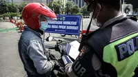 Polisi memeriksa surat-surat pengendara motor saat penyekatan PPKM Darurat di kawasan Ratu Plaza, Jakarta, Sabtu (17/7/2021). Menko PMK Muhadjir Effendy menerangkan perpanjangan PPKM Darurat untuk menekan penularan COVID-19 sudah diputuskan Presiden RI Joko Widodo. (Liputan6.com/Faizal Fanani)