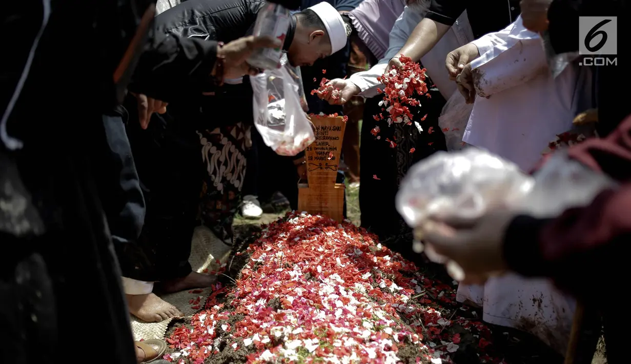 Keluarga dan kerabat menaburkan bunga di makam almarhum istri kedua Opick, Wulan Mayasari di TPU Semper, Jakarta, Senin (19/3). Wulan Mayasari dan bayi yang dikandungnya meninggal dunia. (Liputan6.com/Faizal Fanani)