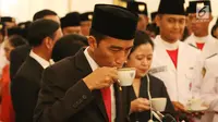 Presiden Joko Widodo (Jokowi) saat mencicipi kopi lokal di ruang belakang Istana Negara, Jakarta, Selasa (15/8). Jokowi menyicipi kopi tersebut seusai mengukuhkan anggota Paskibraka tahun 2017. (Liputan6.com/Angga Yuniar)