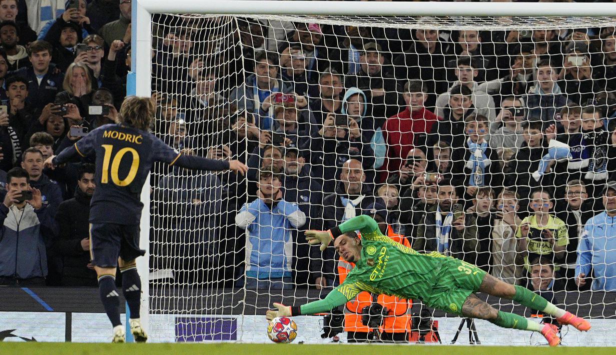Kiper Manchester City, Ederson berhasil menggagalkan eksekusi penalti pertama Real Madrid yang diambil Luka Modric saat adu tendangan penalti pada laga leg kedua perempatfinal Liga Champions 2023/2024 di Etihad Stadium, Manchester, Rabu (18/4/2024). (AP Photo/Dave Shopland)