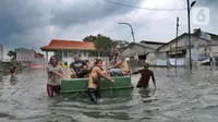 Warga menaiki benda terapung untuk melewati banjir rob di kawasan Pelabuhan Sunda Kelapa, Jakarta, Selasa (7/12/2021). Banjir rob setinggi satu meter memutus Jalan Kerapu yang menghubungkan Ancol-Pluit. (merdeka.com/Arie Basuki)