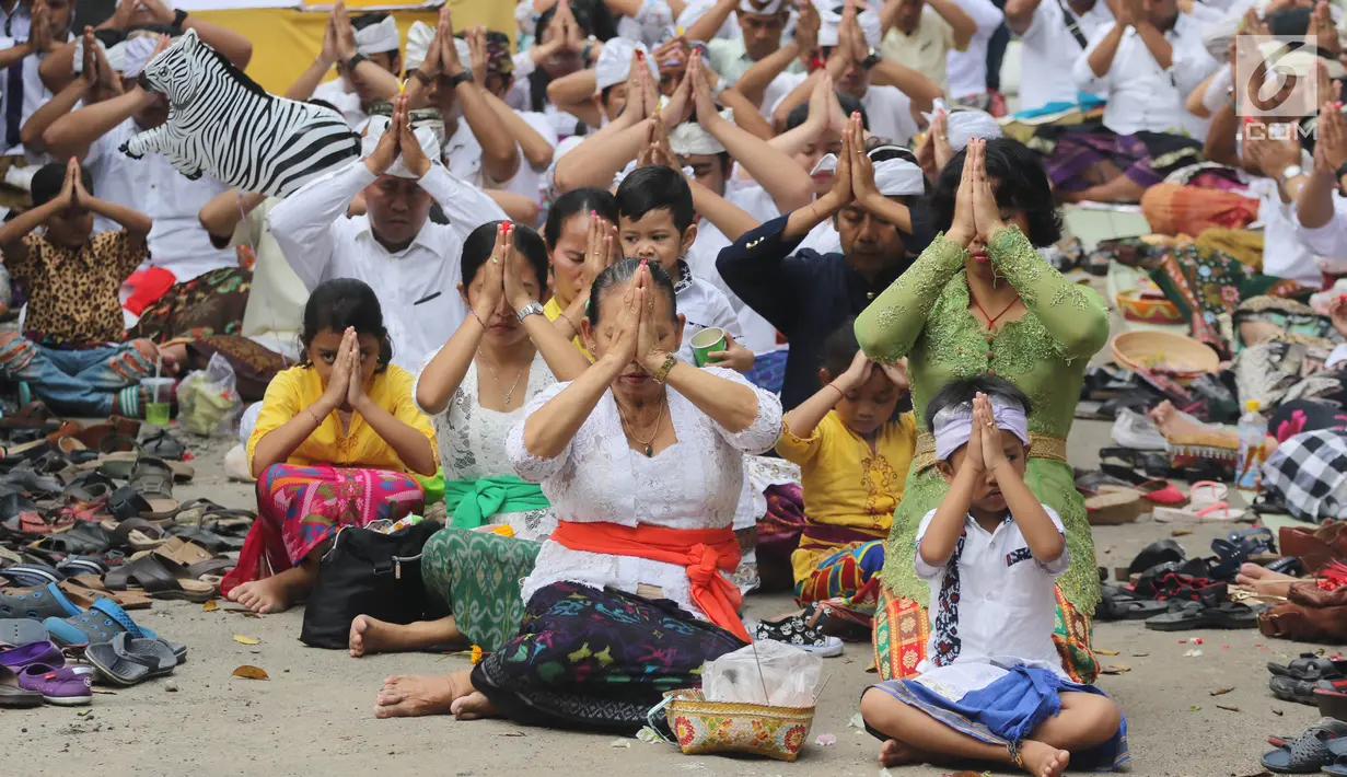 Sejumlah umat Hindu sembahyang saat upacara Tawur Kesanga di Pura Aditya Jaya, Rawamangun, Jakarta, Jumat (16/3). Upacara ini sekaligus menciptakan keseimbangan antara buana alit (manusia) dan buana agung (alam semesta). (Liputan6.com/Arya Manggala)
