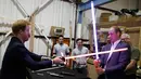 Pangeran William dan Harry bermain pedang sinar saat berkunjung ke studio pembuatan film Star Wars di Pinewood Studios, London, Selasa (19/4). Dua Pangeran Inggris itu berkeliling Pinewood untuk mengunjungi workshop produksi film Star Wars (REUTERS/Pool)