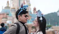 Liburan bareng ke Disneyland Hong Kong, keduanya juga tampil serasi dengan mantel dan headpiece. [Foto: @raynwijaya26]