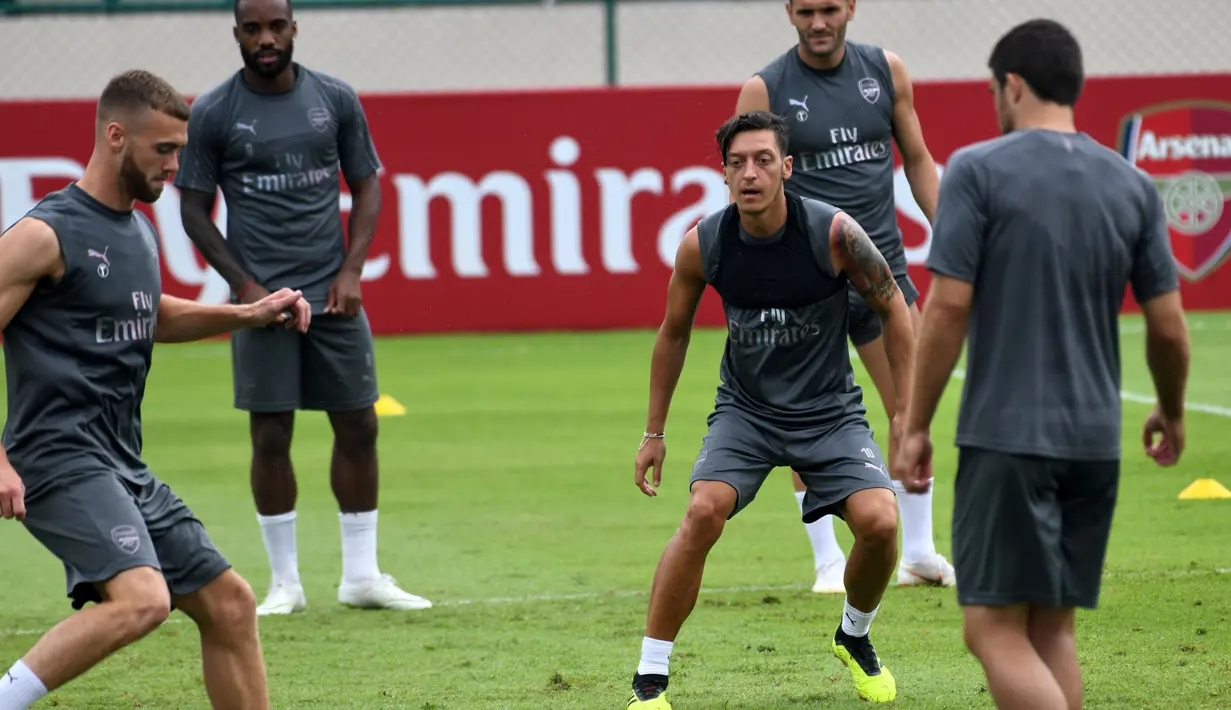 Pemain Arsenal, Mesut Ozil dan rekan setimnya menjalani latihan untuk kompetisi pramusim International Champions Cup (ICC) 2018 di Singapura, Rabu (27/5). Menjelang duel kontra Atletico Madrid, Ozil dkk menikmati sesi latihan ringan. (AFP/Roslan RAHMAN)