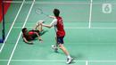 Pebulu tangkis tunggal putra Indonesia Anthony Sinisuka Ginting (kiri) terjatuh saat melawan tunggal putra China Shi Yu Qi pada babak 16 besar Indonesia Masters 2023 di Istora Senayan, Jakarta, Kamis (26/1/2023). Anthony Sinisuka Ginting terhenti di babak 16 besar Indonesia Masters 2023 setelah kalah dari Shi Yu Qi dengan skor 19-21 dan 16-21. (Liputan6.com/Herman Zakharia)