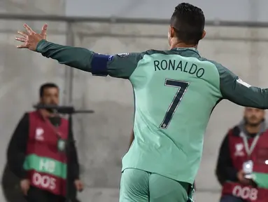 Pemain timnas Portugal, Cristiano Ronaldo merayakan golnya ke gawang Andorra pada Kualifikasi Piala Dunia 2018 zona Eropa di Stadion Nasional Andorra, Minggu (8/10). Portugal menang 2-0 lewat gol Ronaldo dan Andre Silva. (PASCAL PAVANI/AFP)