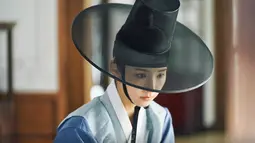 Kang Hee Soo memakai gat (topi tradisional Korea) dan mengenakan pakaian pria berwarna biru saat ia menyamar sebagai pria. Dia tampil elegan dan sikapnya memadukan visual tampan dan cantik. (Foto: tvN)