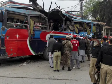 Petugas melakukan pemeriksaan kondisi bus rombongan pegawai Pakistan usai diserang bom di Peshawar, Pakistan, Rabu (16/3). Bus yang membawa rombongan pegawai pemerintah ini menewaskan setidaknya 10 orang dan 27 lainnya terluka. (REUTERS/Fayaz Aziz)