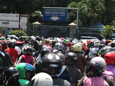 Warga memadati lajur pintu masuk area parkir motor kawasan Kebun Binatang Ragunan, Jakarta, Minggu (30/12). Libur panjang jelang pergantian tahun dimanfaatkan warga untuk berlibur di kawasan Kebun Binatang Ragunan. (Liputan6.com/Helmi Fithriansyah)