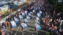 Warga yang datang ke acara CFD melihat arak-arakan bendera di kawasan Bundaran HI, Jakarta, Minggu (30/10). Parade ini merupakan rangkaian arak-arakan parade Bendera Menjelang Sidang Umum Interpol Ke-85. (Liputan6.com/Johan Tallo)