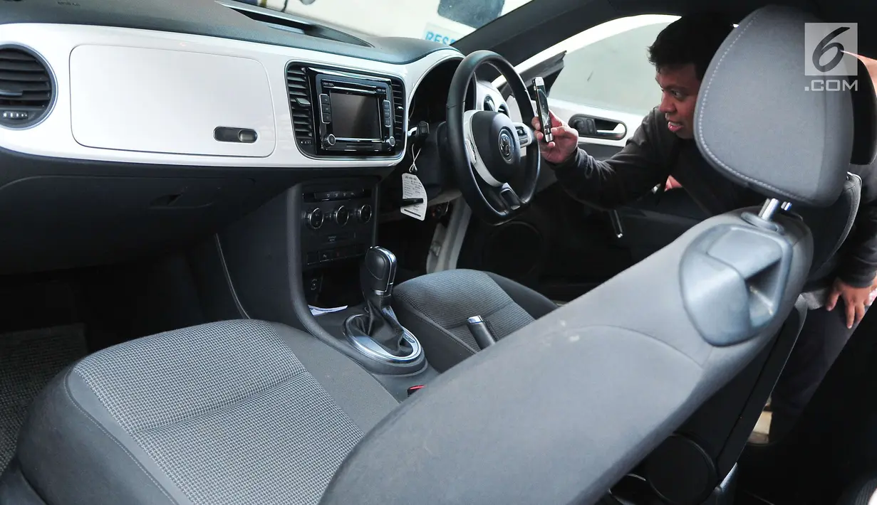 Calon peserta lelang mengambil gambar interior mobil hasil sitaan kasus korupsi di Gedung KPK, Jakarta, Selasa (19/9). KPK melelang sebanyak 19 unit mobil dari berbagai model dan merek dengan harga termurah Rp28,8 jutaan. (Liputan6.com/Helmi Afandi)