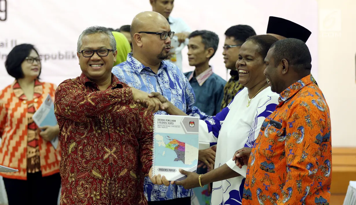 Ketua KPU Arief Budiman memberikan buku saat acara rapat Penyampaian Penetapan Daerah Pemilihan dan Alokasi Kursi Anggota DPRD Kab/Kota Pemilu 2019 di Kantor KPU Pusat, Jakarta, Rabu (18/4). (Liputan6.com/JohanTallo)