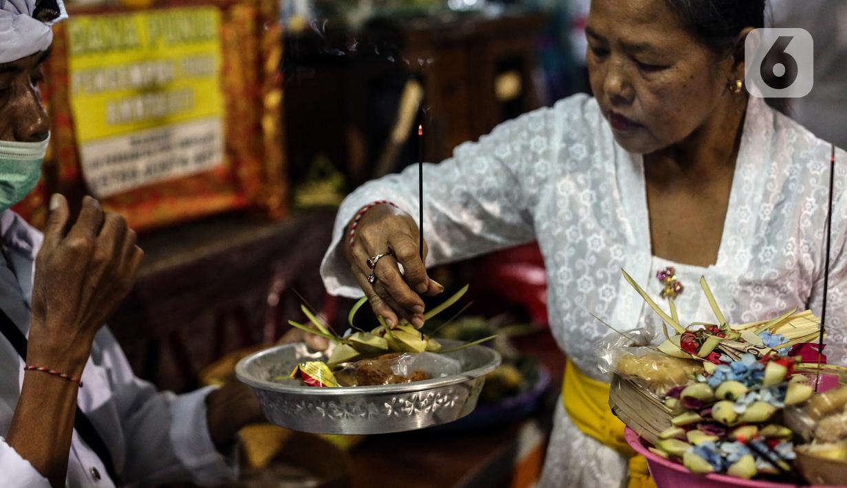 Umat Hindu Bali menyalakan dupa saat merayakan Hari Raya Galungan di Pura Amerta Jati, Jalan Punak, Pangkalan Jati, Cinere, Depok, Jawa Barat, Rabu (8/6/2022). Hari Raya Galungan merupakan hari merayakan kemenangan kebaikan (Dharma) melawan kejahatan (Adharma). (Liputan6.com/Johan Tallo)