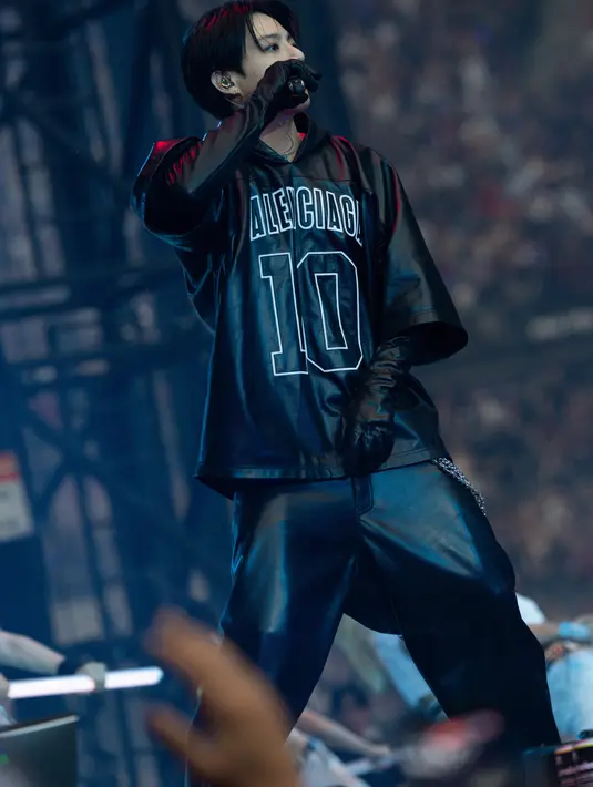 Kali ini Jung Kook tampil bergaya khas boyband dengan teatrikal. Ia mengenakan sarung tangan opera, celana XXL, dan hooded oversized short sleeves dengan logo bordir dan angka 10, alamat bersejarah Balenciaga di Paris, di Avenue George V. [Balenciaga]