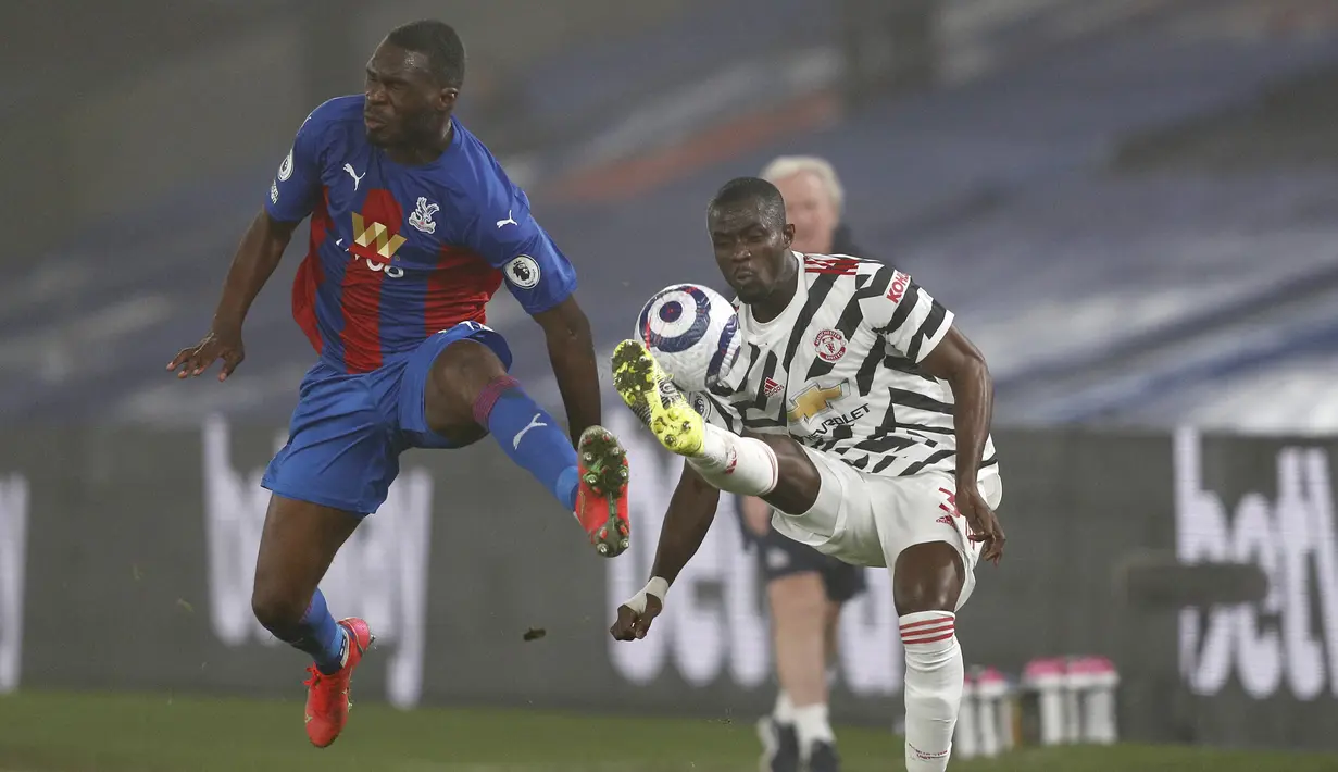 Striker Crystal Palace, Christian Benteke (kiri) berebut bola dengan bek Manchester United, Eric Bailly dalam laga lanjutan Liga Inggris 2020/21 pekan ke-27 di Selhurst Park, Rabu (3/3/202). Crystal Palace bermain imbang 0-0 dengan Manchester United. (AFP/Adrian Dennis/Pool)