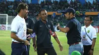 Pelatih Persebaya Surabaya, Wolfgang Pikal (kiri), tampak terlibat sebuah perdebatan dengan pelatih Persela Lamongan, Nilmaizar (menggunakan topi), usai pertandingan antara kedua tim yang berakhir 1-0 untuk kemenangan Persela, Rabu (23/10/2019). (Bola.com/Aditya Wany)