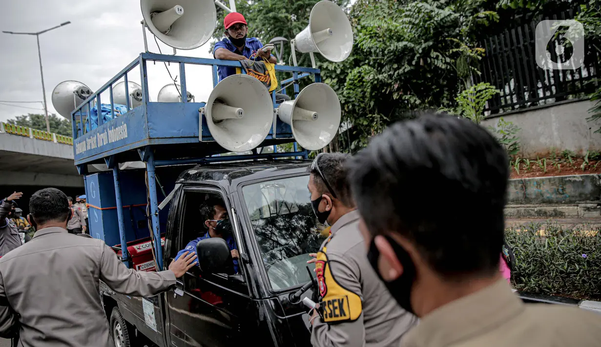 Petugas kepolisian yang berjaga memberhentikan mobil komando aksi di sekitar Gedung DPR, Jakarta, Jumat (14/8/2020). Polda Metro Jaya melarang adanya unjuk rasa di depan Gedung DPR/MPR yang bertepatan dengan sidang tahunan sekaligus pidato kenegaraan Presiden Jokowi. (Liputan6.com/Faizal Fanani)