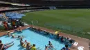Sejumlah penonton terlihat serius menyaksikan pertandingan kriket antara Australia dan Pakistan di dalam kolam renang di stadion Gabba di Brisbane, Australia (15/12). (AFP Photo/Saeed Khan)
