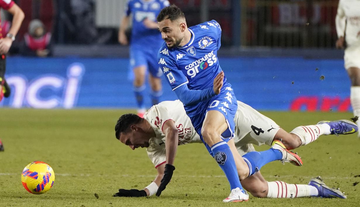 Gelandang Empoli, Nedim Bajrami berebut bola dengan gelandang AC Milan, Ismael Bennacer pada pertandingan Liga Serie A Italia di Stadion Carlo Castellani di Empoli, Italia, Kamis (23/12/2021). AC Milan menang atas Torino 4-2. (Marco Bucco/LaPresse via AP)