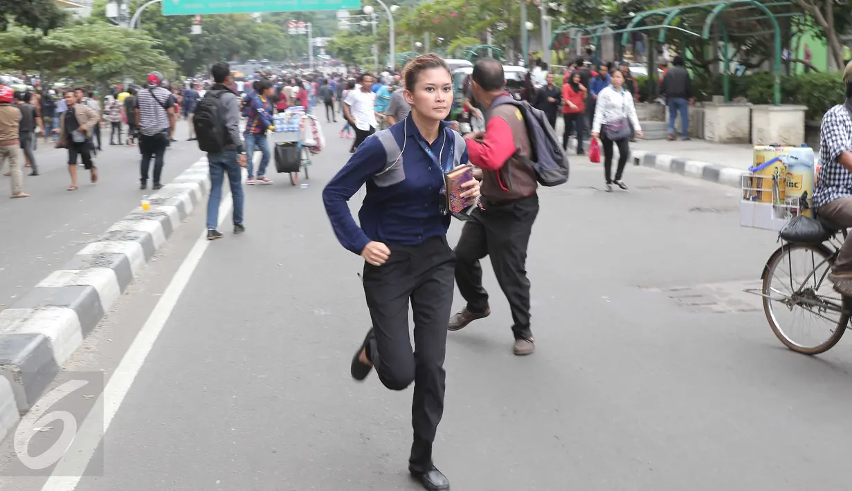 Presenter sebuah televisi swasta, Marissa Anita berlari usai mendengar isu bom yang akan kembali meledak pasca terjadinya ledakan yang terjadi di Pos polisi dekat pusat perbelanjaan Sarinah, Jalan Thamrin, Jakarta, Kamis (14/1) (Liputan6.com/Angga Yuniar)