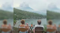 Turis asing melihat letusan Gunung Agung dari Amed. (Twitter@@Sutopo_BNPB)