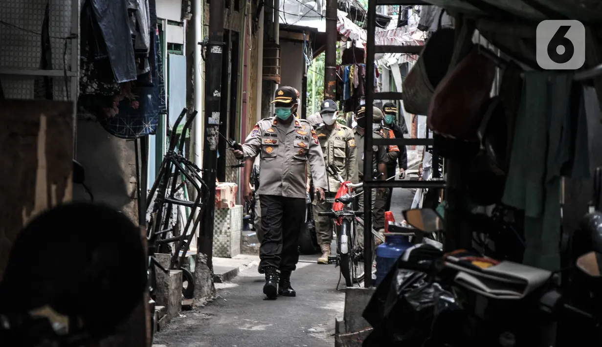 Petugas gabungan menyisir pemukiman warga saat pemberlakuan mikro lockdown di RW 002, Kelurahan Krukut, Taman Sari, Jakarta Barat, Senin (10/1/2022). Selain mikro lockdown, petugas melakukan tes massal kepada warga setempat guna mencegah penularan COVID-19 lebih luas. (merdeka.com/Iqbal S. Nugroho)