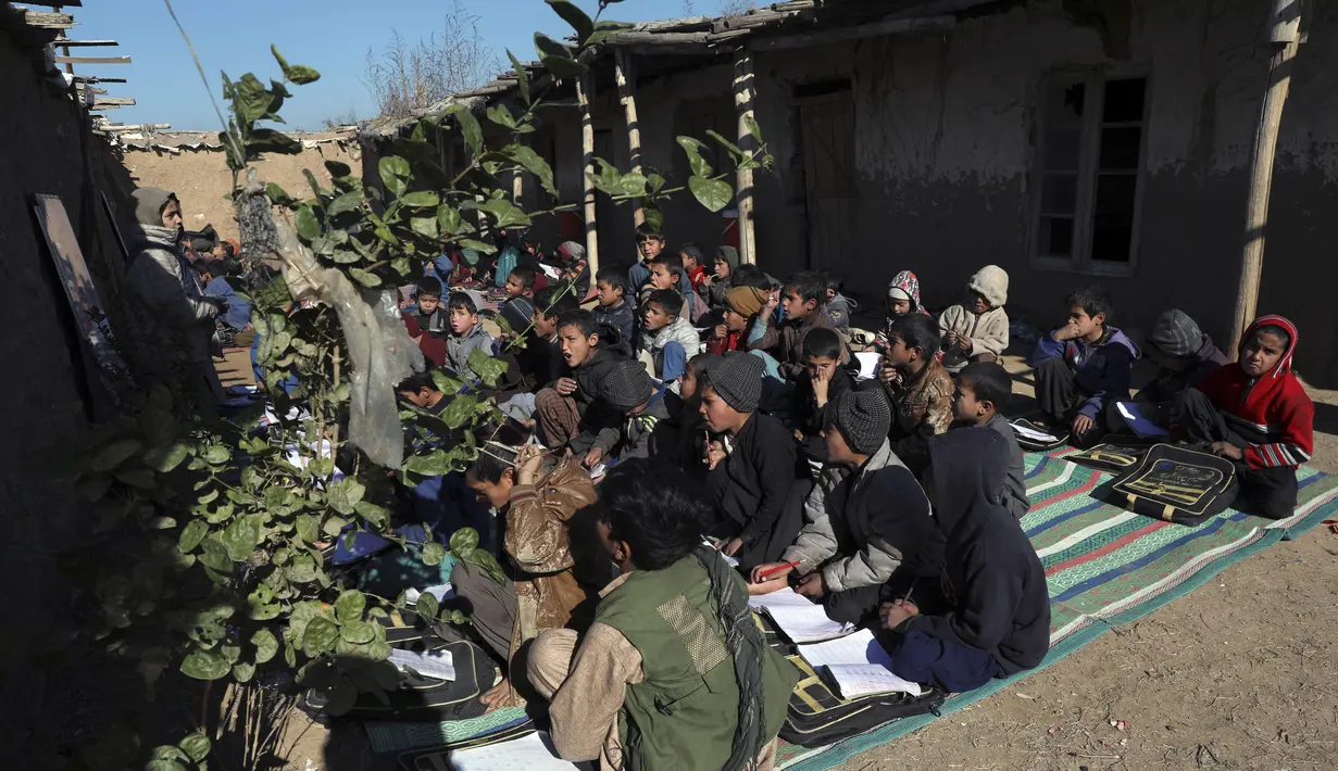 Anak-anak sekolah pengungsi Afghanistan menghadiri kelas di sekolah darurat di pinggiran Islamabad, Pakistan, Rabu (29/12/2021). (AP Photo/Rahmat Gul)