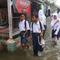 Anak-anak sekolah menerobos banjir rob yang menggenangi rumah dan tambak warga di Desa Pantai Mekar, Muaragembong, Kabupaten Bekasi, Jawa Barat, Senin (6/12/2021). Banjir rob telah menggenangi wilayah tersebut selama empat hari akibat kenaikan permukaan air laut. (Liputan6.com/Herman Zakharia)