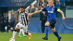 Penyerang Juventus, Carlos Tevez berusaha melewati bek AS Monaco Andrea Raggi di leg 8 besar Liga Champions di Juventus Stadium, Italia, Rabu (15/4/2015). Juvenetus Menang 1-0 atas AS Monaco. (Reuters/Stefano Rellandini)