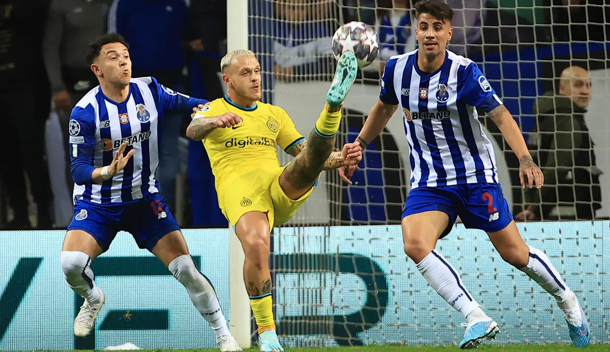 Pemain Inter Milan Federico Dimarco mencoba melakukan tendangan ke gawang di antara pemain FC Porto Pepe (kiri) dan Fabio Cardoso (kanan) pada pertandingan leg kedua babak 16 besar Liga Champions di Stadion Dragao, Porto, Portugal, 14 Maret 2023. Laga berakhir imbang tanpa gol sehingga Inter Milan melaju dengan hasil agregat 1-0. (AP Photo/Luis Vieira)