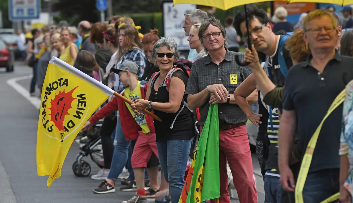 Sejumlah demonstran bersiap membentuk rantai manusia dalam aksi protes di Aachen, Jerman barat, 25 Juni 2017. Ribuan orang menuntut penutupan dua reaktor nuklir, yakni reaktor nuklir Tihange dan reaktor nuklir Doel di Belgia. (Henning Kaiser/dpa/AFP)
