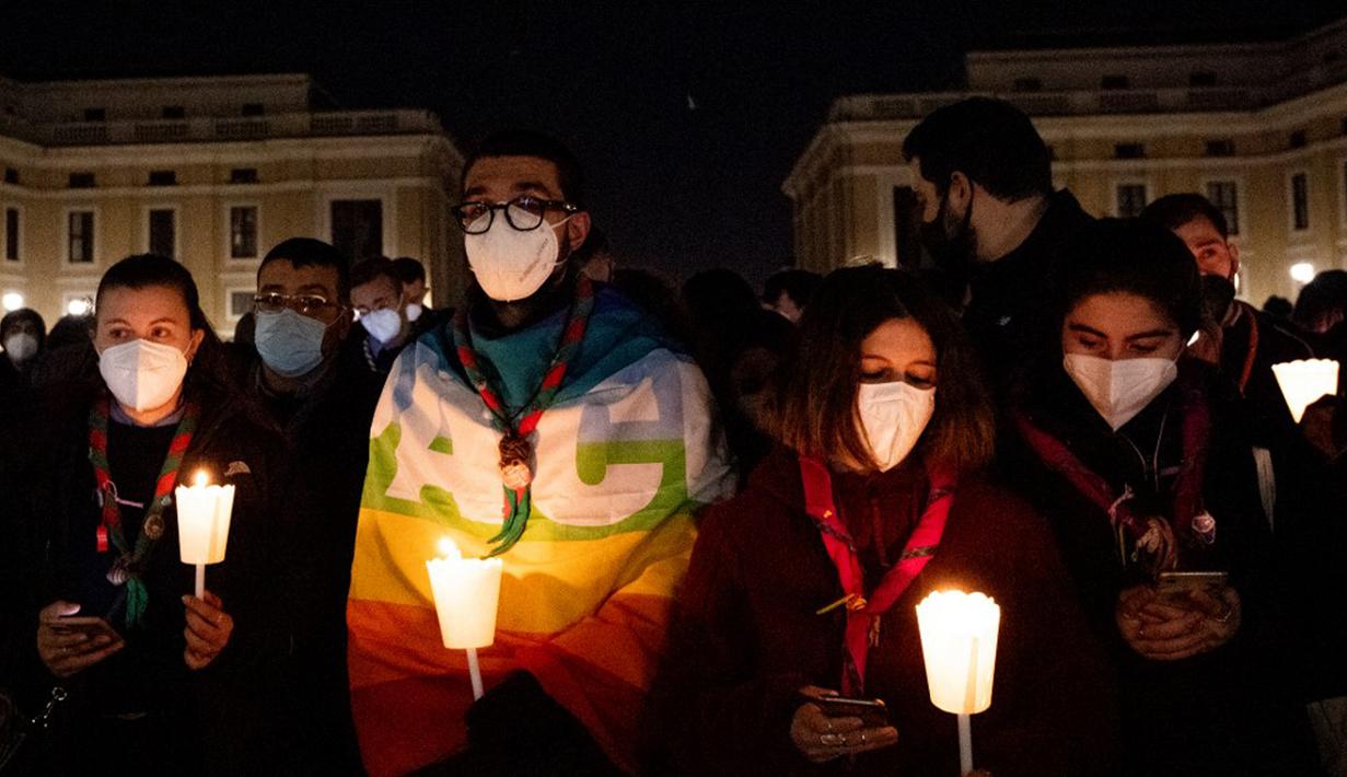 Orang-orang yang percaya memegang lilin saat berdoa untuk perdamaian Ukraina di Lapangan Santo Petrus, Vatikan, 2 Maret 2022. (Tiziana FABI/AFP)