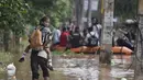 Seorang anak diantar ke sekolah saat banjir melanda kawasan Gauhati, India, Rabu (14/6). Angin monsun yang mendatangi India berdampak pada tingginya curah hujan yang menyebabkan banjir. (AP Photo / Anupam Nath)