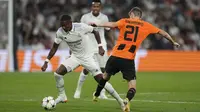 Bek Real Madrid David Alaba berebut bola dengan gelandang Shakhtar Donetsk Artem Bondarenko dalam matchday ketiga Grup F Liga Champions 2022/2023 di Santiago Bernabeu, Kamis dini hari WIB (6/10/2022). Tiga gol Madrid yang tercipta dalam laga ini seluruhnya tercipta di babak pertama. (AP Photo/Bernat Armangue)