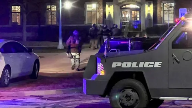 Petugas polisi dengan senjata terhunus memasuki Phillips Hall di Michigan State University di East Lansing setelah laporan penembakan di kampus Senin, 13 Februari 2023. (Jakkar Aimery/Detroit News via AP)