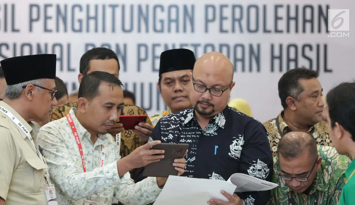 Komisioner KPU RI, Ilham Saputra bersama perwakilan partai politik mengecek keabsahan dokumen rekap penghitungan suara Provinsi Bali saat rapat Rekapitulasi Hasil Penghitungan Perolehan Suara Tingkat Nasional dan Penetapan Hasil Pemilu 2019, Jakarta, (10/5/2019). (Liputan6.com/Helmi Fithriansyah
