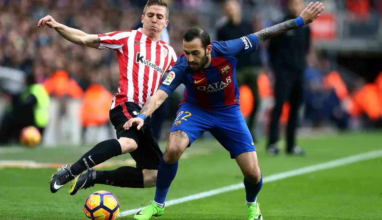 Gelandang Barcelona, Aleix Vidal, menghadang striker Athletic Bilbao, Iker Muniain. Kemenangan ini memantapkan posisi Barcelona di peringkat kedua klasemen Liga Spanyol menempel Real Madrid. (EPA/Toni Albir)