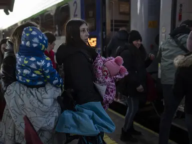 Orang-orang yang melarikan diri dari perang di Ukraina menunggu di stasiun kereta api di Przemysl, Polandia tenggara, Kamis (17/3/2022). Polandia telah menerima sekitar 1,95 juta pengungsi yang melarikan diri dari perang dan agresi Rusia di Ukraina. (AP Photo/Petros Giannakouris)