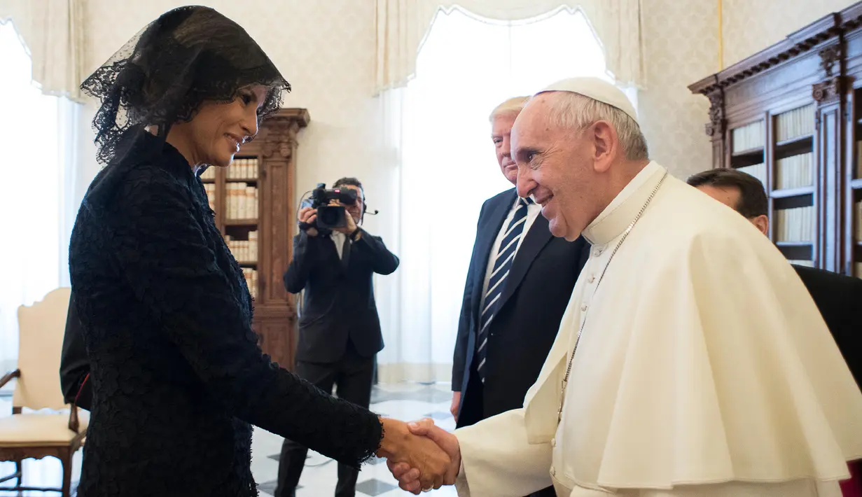 Ibu Negara AS, Melania Trump berjabat tangan dengan Paus Fransiskus pada pertemuan pribadi bersama Presiden AS,  Donald Trump di Vatikan, (24/5). Melania Trump mengenakan penutup kepala hitam saat menemui Paus. (L'Osservatore Romano/Pool Photo via AP)